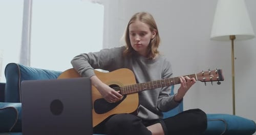 Woman Playing Acoustic Guitar at Home