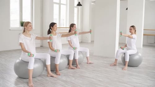 Gruppe schwangerer Frauen, die auf einem Fitnessball sitzen und Sport treiben