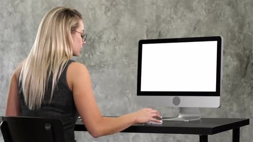 Woman Typing at Computer with White Screen