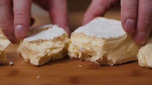 People Cut Cheese with a Knife on Old Wooden Table Break Brie Close Up Macro Cheese