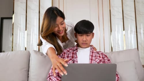 Young Man Working on Laptop, Woman Talks to Him