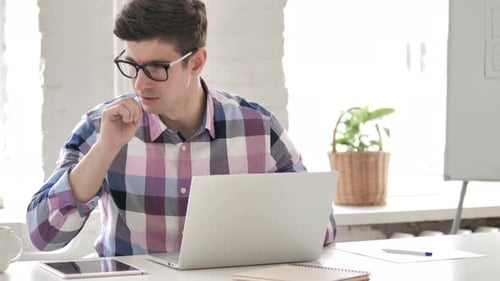 Man Working at Desk Coughs While Typing