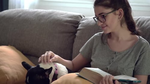 A girl sitting on the sofa and reading a book in cozy home