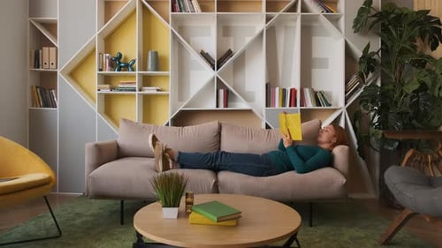 Woman Reading a Book on Couch at Home