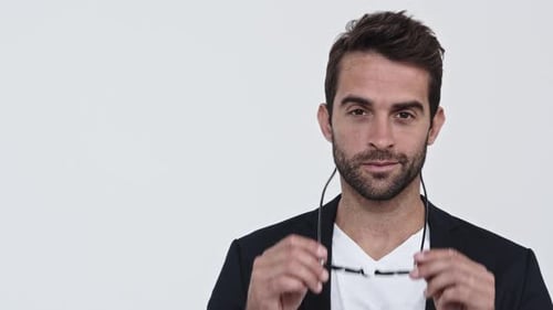 Smiling Man Puts on Black Glasses and Laughs