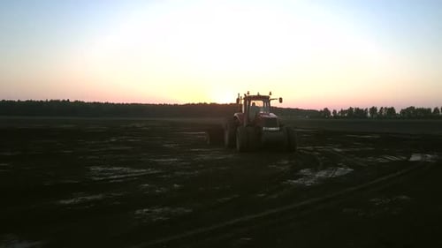 Cultivator with Harrow Plows Field in Evening Aerial View