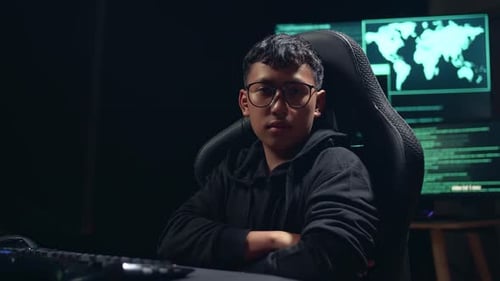 Asian Boy Hacker Using Computer Hacking And Looking, Pose To Camera