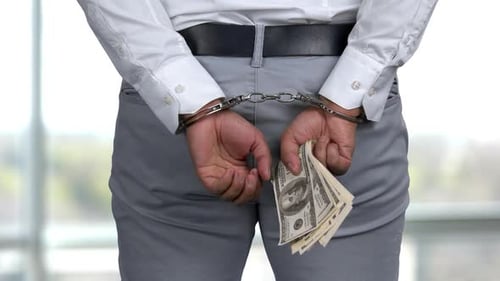 Handcuffed Man Holding Money Behind Back