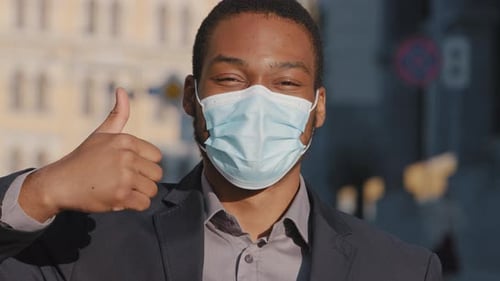 Young Adult With Mask Gives Thumbs Up