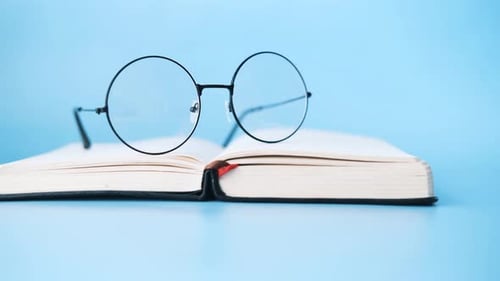 Open Book and a Eyeglass on Blue Background