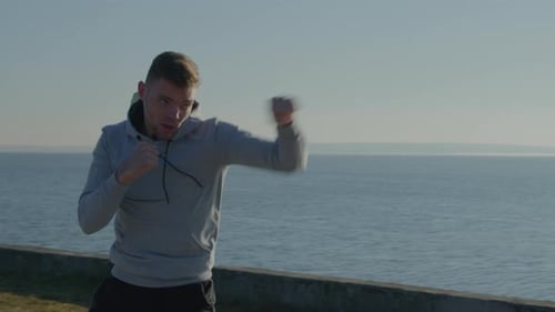 Young Adult Shadow Boxing on Coastal Path