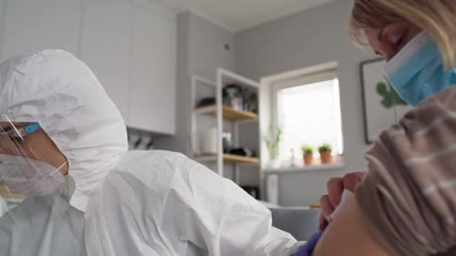 Close up video of senior woman during vaccination at home. Shot with RED helium camera in 8K.