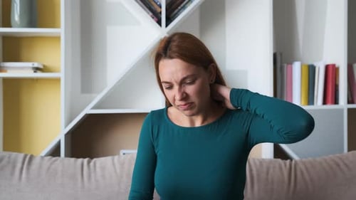 Close Up of the Young Woman Holding Her Neck Behind As She Having Headache