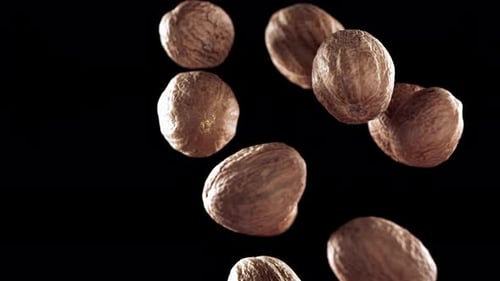 Walnuts Slowly Falling Against Black Background