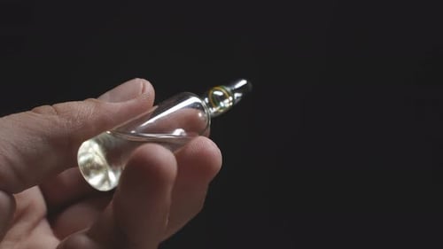 Man's Hand Holds an Ampoule for Injection on a Dark Background. Coronavirus, Pandemic
