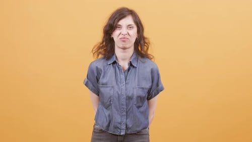 Mulher bonita sobre fundo amarelo mostrando rostos engraçados para a câmera