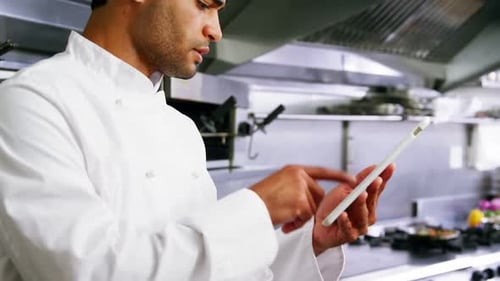 Male chef using digital tablet in commercial kitchen