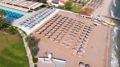 Flight Over the Beach with Umbrellas Towards the Pool in a Luxury Hotel