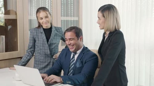 Group of young business people working on desk together with one laptop in office