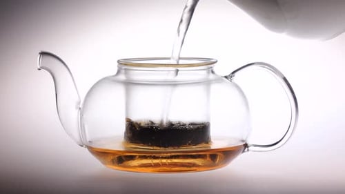 Water Being Poured into a Glass Teapot