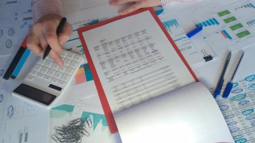 Close Up of a Businessman Hands with Pen Working at Office Desk and Analyzing Graphs and Charts in