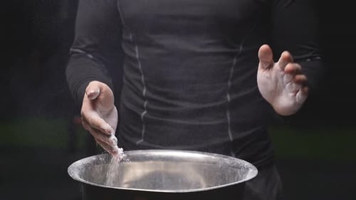 Muscular Caucasian Man Clapping Hands with Talc and Preparing for Workout at Gym