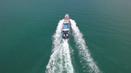 Passenger Boat Cruising Across Turquoise Ocean Water