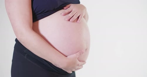 Pregnant Woman Holding Belly in a Home Setting