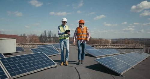 Ingeniero y técnico discutiendo entre paneles solares