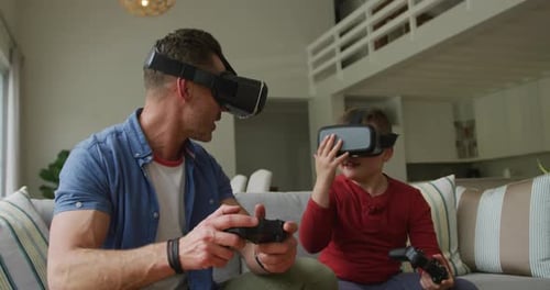 Caucasian father with son using vr headsets and sitting in living room