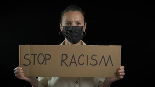 Woman Wearing Mask Holds "Stop Racism" Sign