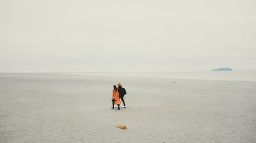 Couple Walking Towards Mont Saint-Michel on Barren Land