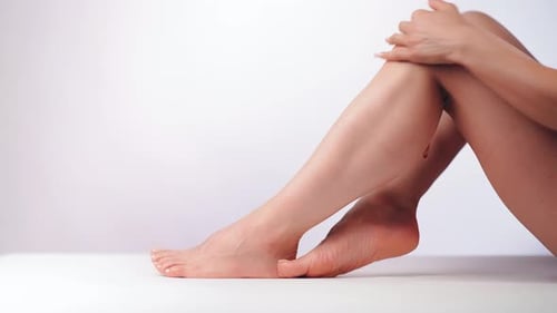 Woman Applying Lotion to her Leg