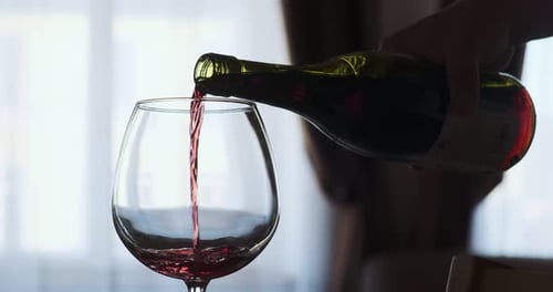 Closeup de enchimento de taça de vinho com vinho tinto em super Câmera lenta