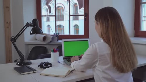 Businesswoman Entering Data on Laptop