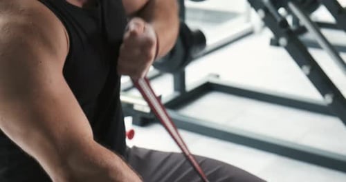 Young Musculary Man Is Bandaging Arm with Bandage in the Gym Before Training. Slow Motion
