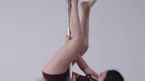 Pole Dancing in the Studio Brunette Woman Slowly Spinning on the Pole Upside Down