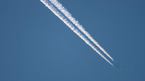 Jet Airplane Flying Through Blue Sky Leaving Contrails