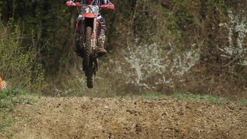 Motocross Riders Jumping on Dirt Track