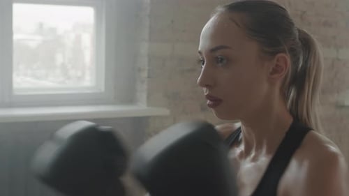 Determined Woman Boxer Training Hard in Gym