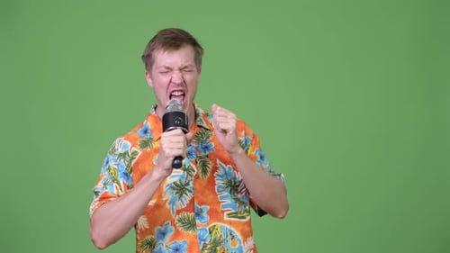 Passionate Young Adult Singing Into Microphone On Green Screen