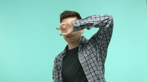 Cheerful Young Man in Glasses Dancing Showing Peace Disco Gesture and Smiling Having Fun Standing