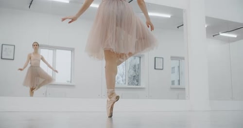 Elegant Ballerina Practices Ballet Moves in Dance Studio