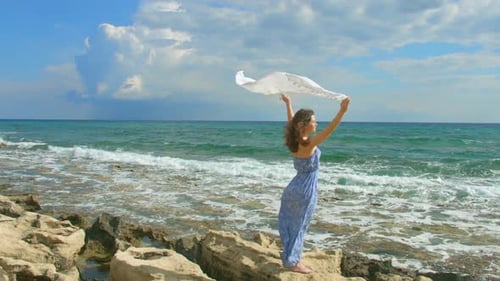 Young Woman with Scarf on a Rocky Beach