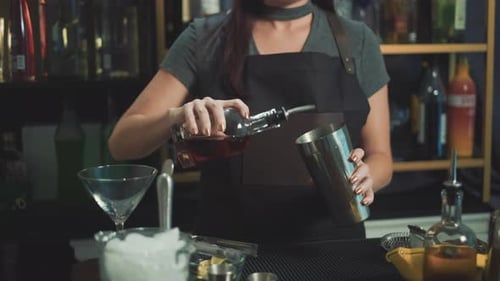 Woman Mixologist Pouring Cocktail at Elegant Bar