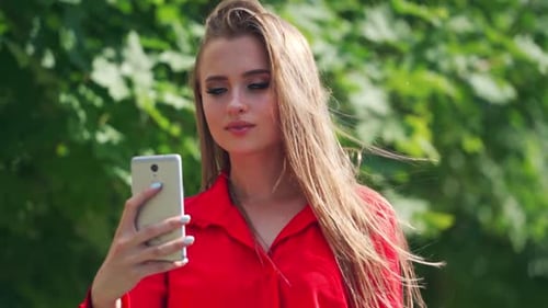 Attractive Woman Using Smartphone Outdoors in Sunlight