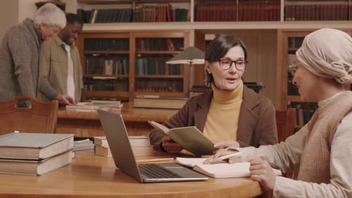 Professor and University Student Studying in Library