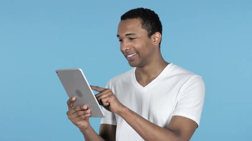 Adult Using Tablet Device Against Blue Background
