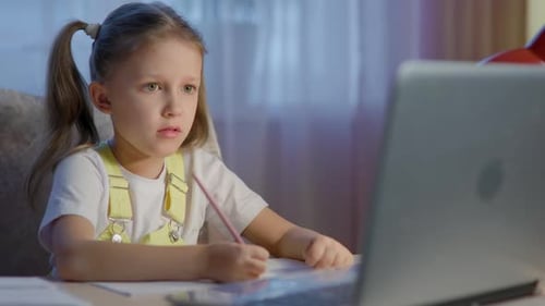 Girl Doing Homework on Laptop at Night