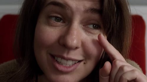 Woman Smiling and Touching Her Face in Close Up